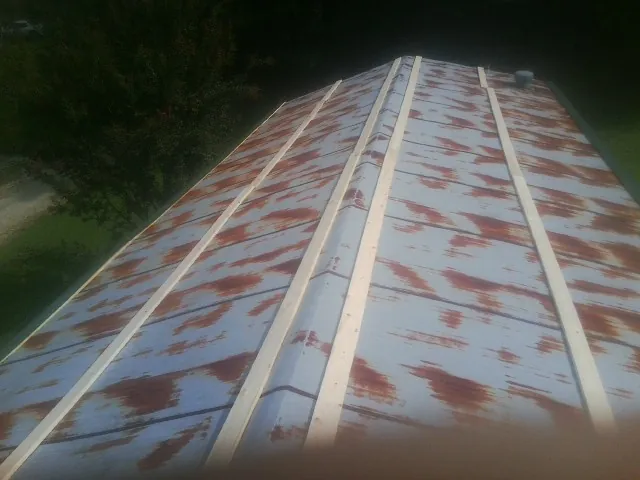 Rusted metal roof panels with new wood purlins before replacement — Storm Damage Roof Repair in Perryopolis by Roofing Brothers