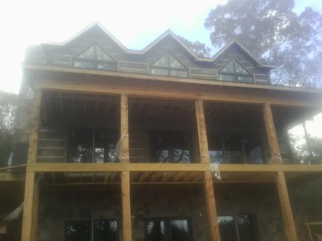 Dormers and porch framing on a large log home under construction — Roof Coating work by our crew in Perryopolis