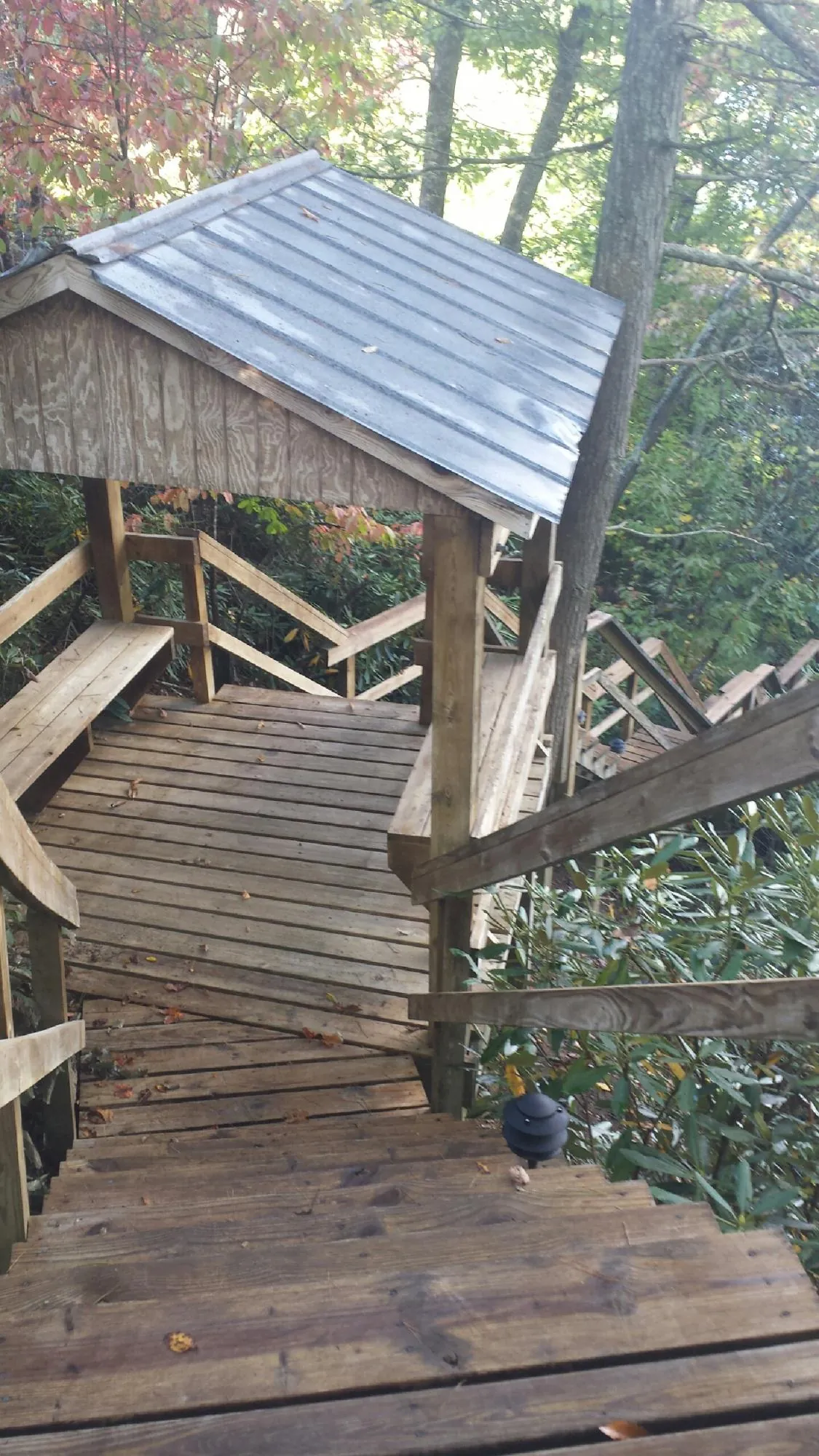 Metal roofed shelter over wooden steps on a wooded walkway — Skylight Repair & Installation work by our crew in Perryopolis