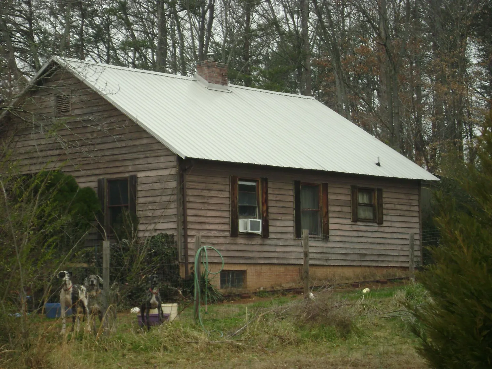 White metal roof on an old wood sided farmhouse, from a Metal Roof Installation job in Perryopolis
